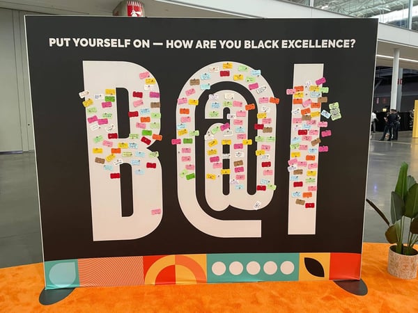 A banner from INBOUND 2022 that says, 'Put Yourself On—How Are You Black Excellence? B@I.' Cards with messages about Black Excellence are pinned over the section that says B@I.